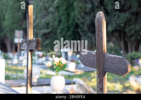 Mehrere alte braune Holzruinen markieren unbekannte Gräber auf einem Friedhof Stockfoto