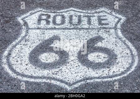 Symmetrische Nahaufnahme eines weißen Wegweisses Route 66, der auf dem Asphalt gemalt ist Stockfoto