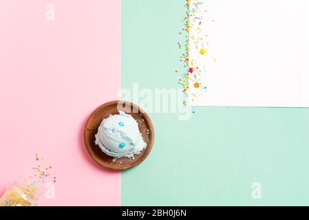 Kugeln aus frischem, natürlichem, hausgemachtem Eis in einem hölzernen Oliventeller auf einem tricolor pastellfarbenen Hintergrund und süßer Dekoration. Draufsicht. Stockfoto