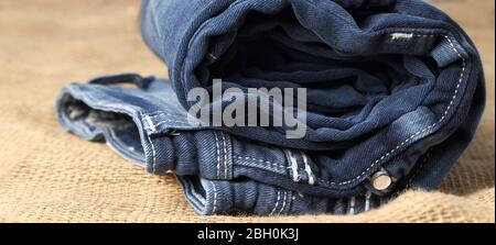 Old Blue Jeans Mode-Design auf braunen Hanf Sack Textur Hintergrund,.Ripped Jeans eines Stapels Hipster Mode kopieren Raum für Textkommentar . Stockfoto