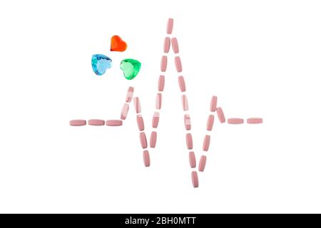 Pillen in Form eines Herzfrequenzpulses auf weißem, isoliertem Hintergrund. Konzept der Pharmazie und Kardiologie. Herzschlag Rhythmus aus Vitamin ist Symbol für Stockfoto