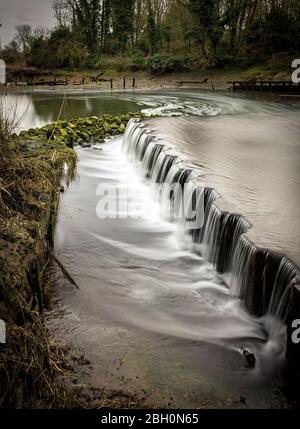 Lange Exposition seidig glattes Wasser fließt über Menschen gemacht Strukturen bei Beeleigh Wasserfälle Stockfoto