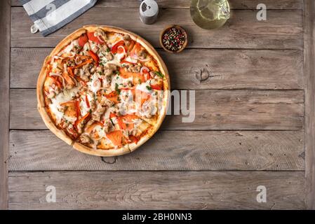 Frische Grill Chicken Pizza mit Gemüse und Mozzarella-Käse auf Holz, Blick von oben, Kopierraum. BBQ Pizza mit Hühnerstücken. Stockfoto