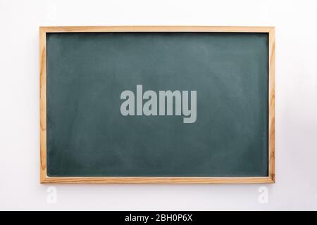 Leere grüne Tafel an einer weißen Wand, Schule und Lehrkonzept, Raum für Text kopieren Stockfoto