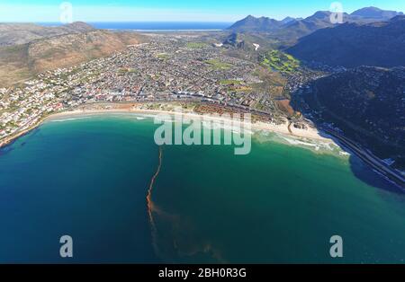 Luftbild der roten Flut am Fish Hoek Beach mit Noordhoek im Hintergrund Stockfoto