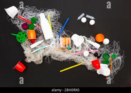 Sortiment an veralteten Plastikmüll-Artikeln auf schwarzem Hintergrund Stockfoto