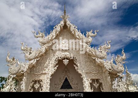 Weißer Tempel, bekannt als Wat Rong Khun mit seiner Spiegelung im Wasser, in Chiang Rai, Thailand. Stockfoto