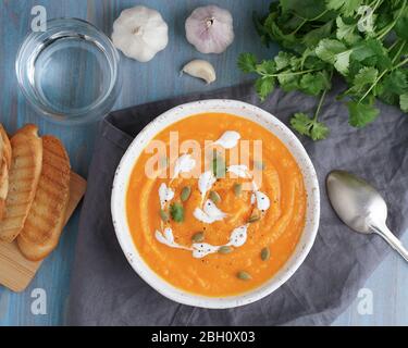 Puppmkin Sahne Suppe Püree, diätetische vegetarische Mittagessen auf blauen Holztisch Stockfoto