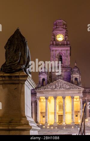 Das Äußere der Portsmouth Guildhall bei Nacht mit der Statue von Königin Victoria im Vordergrund Stockfoto