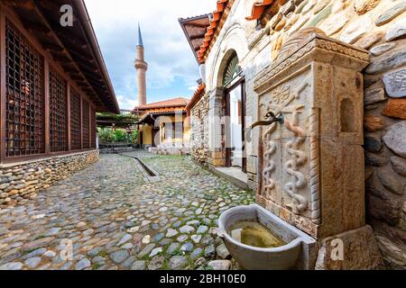 Alter Brunnen mit dem Minarett der Halveti Tekke Moschee im Hintergrund, Prizren, Kosovo Stockfoto