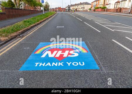 Warrington, Cheshire, Großbritannien. April 2020. Zeichen der Dankbarkeit und Anerkennung für die Arbeit, die das NHS-Personal auf der Straße vor dem Warrington General Hospital in Lovely Lane gemalt hat. Die zwei-Meter-Quadrat-Nachrichten lesen ‘NHS- Thank You' auf einem Hintergrund eines Herzens und Regenbogens Credit: John Hopkins/Alamy Live News Credit: John Hopkins/Alamy Live News Stockfoto