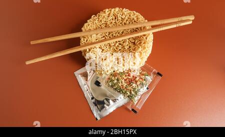 Rohe Instantnudeln mit Essstäbchen und Gewürzen. Kopieren Raum asiatische Lebensmittel. Pasta, für die Vorbereitung, von denen es genug ist, kochendes Wasser zu gießen und warten Stockfoto