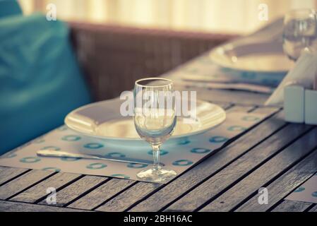 Leere geschirr Tisch im Restaurant mit Glas und Platte, Sommer romantischen Stil in blau und braun Farben Stockfoto