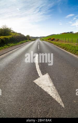 Weiß gemalte Richtungspfeilmarkierung auf der A921 in der Nähe von Dalgety Bay, Fife, Schottland Stockfoto