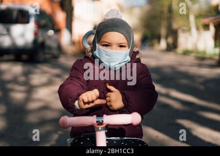 Kleinkind Kind trägt Gesicht medizinische Maske im Freien bei kaltem Wetter. Luftverschmutzung pm2.5 oder Covid-19 Pandemie Stockfoto