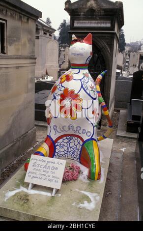 Keramik-Katzenskulptur auf dem Grab von Ricardo Menon, Assistent des Künstlers Niki de Saint Phalle, der im Alter von 37 Jahren starb. Montparnasse Friedhof in Paris Stockfoto