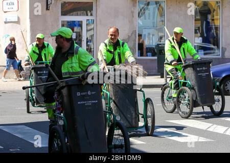 Zagreb, Kroatien - 17. April 2020 : EINE Gruppe Müllmänger, die mit Mülltonnen in der Innenstadt von Zagreb, Kroatien, Fahrrad fahren. Stockfoto