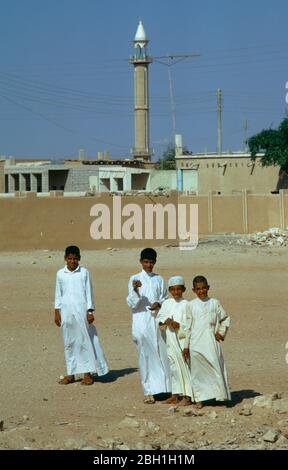 Katar, Khor, Jungen im Fischerdorf vor der Moschee. Stockfoto