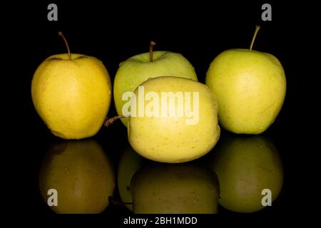 Gruppe von vier ganzen grünen köstlichen Apfel auf schwarzem Glas isoliert Stockfoto