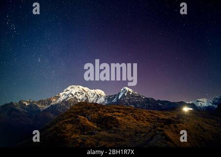 Snowy Annapurna und Hinchuli Berge bei Nacht Sternenhimmel in Nepal Stockfoto