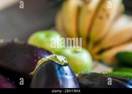 Obst und Gemüse (Bananen und Auberginen) werden gewaschen und desinfiziert, bevor sie das Haus betreten. Diese hygienische Praxis wurde weltweit umgesetzt Stockfoto