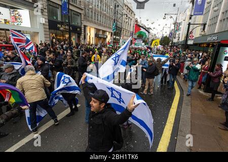Zionistische Gegenprotestierende, die israelische Fahnen beim Nationalen Marsch hochhalten und sich auf die Kundgebung "Justice Now: Make it right for Palestine", London, 2017, einlassen Stockfoto