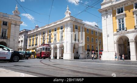 Lissabon, Portugal. Eine typische Straßenszene in der Altstadt mit einer traditionellen Straßenbahn, die über die Kopfsteinpflasterstraße fährt. Stockfoto