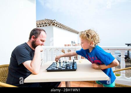 Vater und Sohn spielen Schach auf der Dachterrasse, Spanien Stockfoto