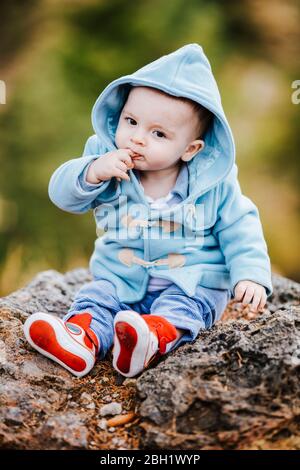 Portrait von Baby Junge tragen hellblaue Kapuzenjacke im Freien Stockfoto
