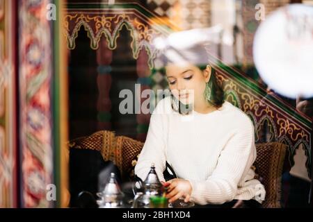Porträt einer nachdenklichen jungen Frau, die in einem Teeladen Tee trinkt Stockfoto