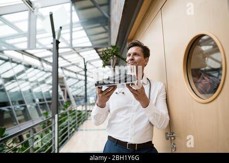 Wissenschaftler beobachten Pflanze in Glasbox wachsen Stockfoto