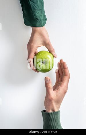 Ansicht von oben, dass eine Frau dem Mann einen grünen Apfel übergab Stockfoto