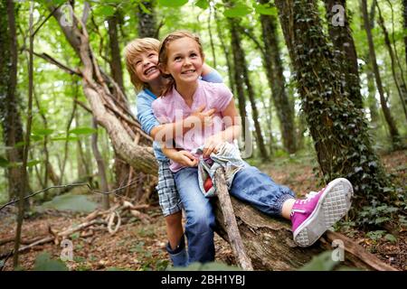 Kinder umarmen sich im Wald Stockfoto