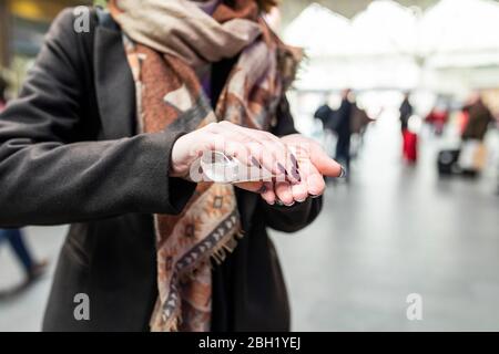 Frau, die am Bahnhof ein desinfizierende Handgel verwendet Stockfoto