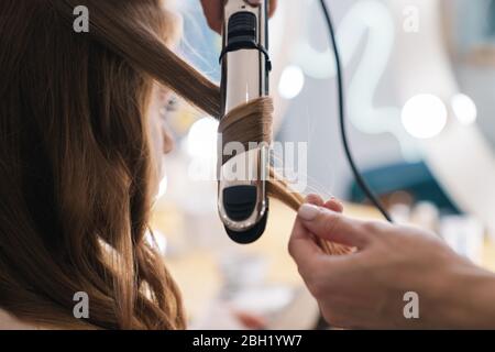 Nahaufnahme eines Friseurs, der die Haare der Kunden im Schönheitssalon lockert Stockfoto