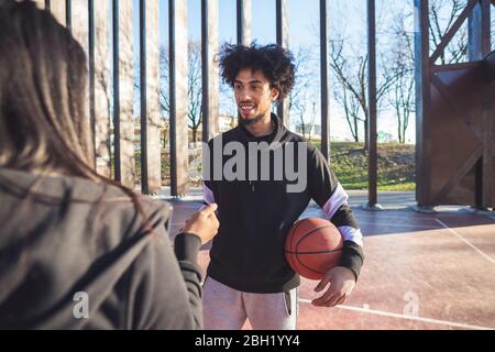 Junger Mann und Frau treffen sich auf dem Basketballplatz Stockfoto