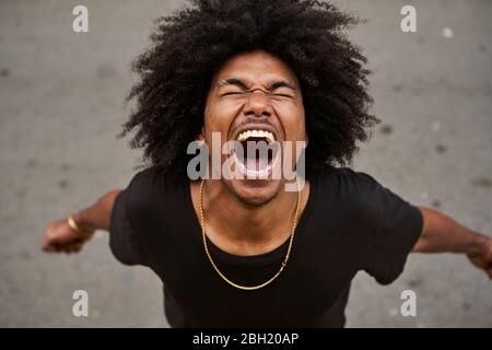 Porträt eines schreienden jungen Mannes mit Afro Stockfoto
