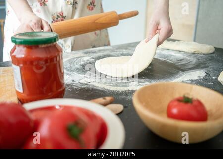 Crop-Ansicht der Frau Ausrollen Teig auf Arbeitsplatte Stockfoto