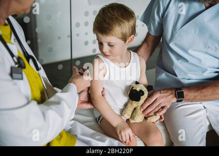 Kinderarzt injiziert Impfstoff in den Arm des Kleinkindes Stockfoto