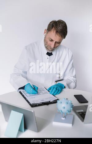 Wissenschaftler, der am Schreibtisch Papiere ausfüllt Stockfoto