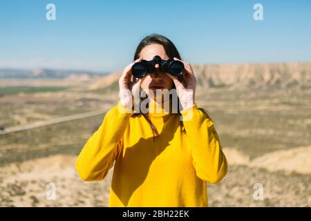 Porträt einer Frau mit Fernglas, Bardenas Reales, Arguedas, Navarra, Spanien Stockfoto