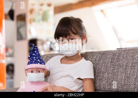 Mädchen trägt Maske zu Hause Stockfoto