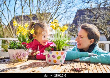 Mutter und Tochter Pflanzen Blumen auf dem Balkon Stockfoto