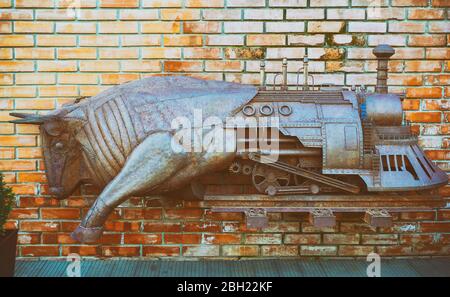 Eisenbullen Lokomotive aus Metall auf einer Ziegelwand Stockfoto