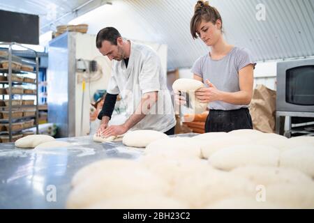 Mann und Frau bereiten Brote in der Bäckerei Stockfoto