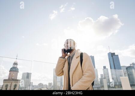 Stilvoller Mann am Telefon auf Aussichtsterrasse mit skycraper-Blick, Frankfurt, Deutschland Stockfoto