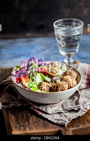 Schüssel mit verzehrfertiger Salatschale mit Spinat-Falafel Stockfoto