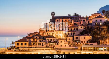 Portugal, Madeira, Camara de Lobos, am Hang gelegene Stadthäuser bei Dämmerung Stockfoto