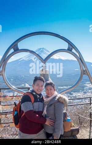 Ein Paar macht ein Foto mit dem Berg Fuji als Hintergrund mit klarem blauen Himmel in Kawaguchiko Stadt. Tokio, Japan 9. Februar 2020 Stockfoto