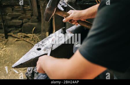 Schmied bei der Arbeit in seiner Werkstatt Stockfoto